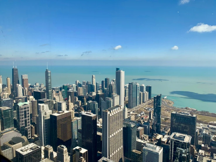 a view of a city from the top of a building, by Robbie Trevino, chicago skyline, clear blue skies, 8k octan photo, group photo