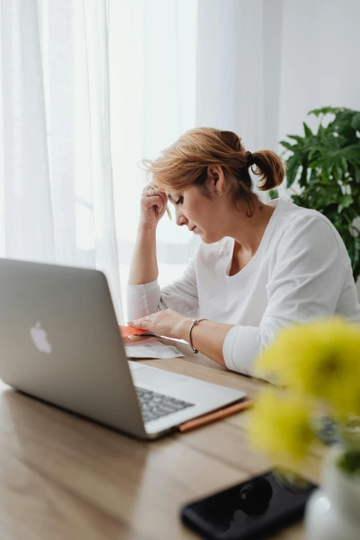 a woman sitting at a table with a laptop, pexels, stressing out, maintenance, ilustration, multiple stories