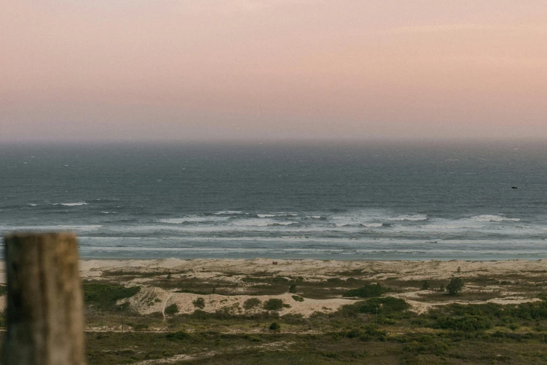 a view of the ocean from the top of a hill, an album cover, unsplash contest winner, australian tonalism, pink hues, ignant, joel meyerowitz, sand and sea