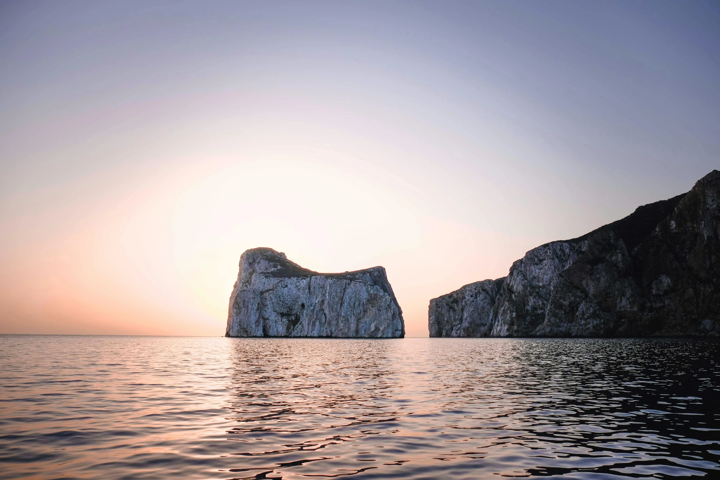 a couple of rocks sitting on top of a body of water, by Simon Marmion, capri coast, warm glow, monoliths, grey