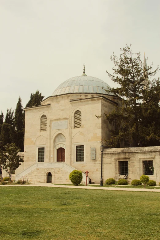 a large building sitting on top of a lush green field, inspired by Altoon Sultan, hurufiyya, mausoleum, wedding, exterior, orthodox