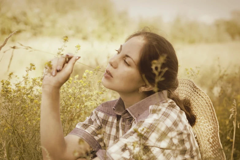 a woman sitting in a field blowing a flower, avatar image, sepia photography, having a picnic, profile image