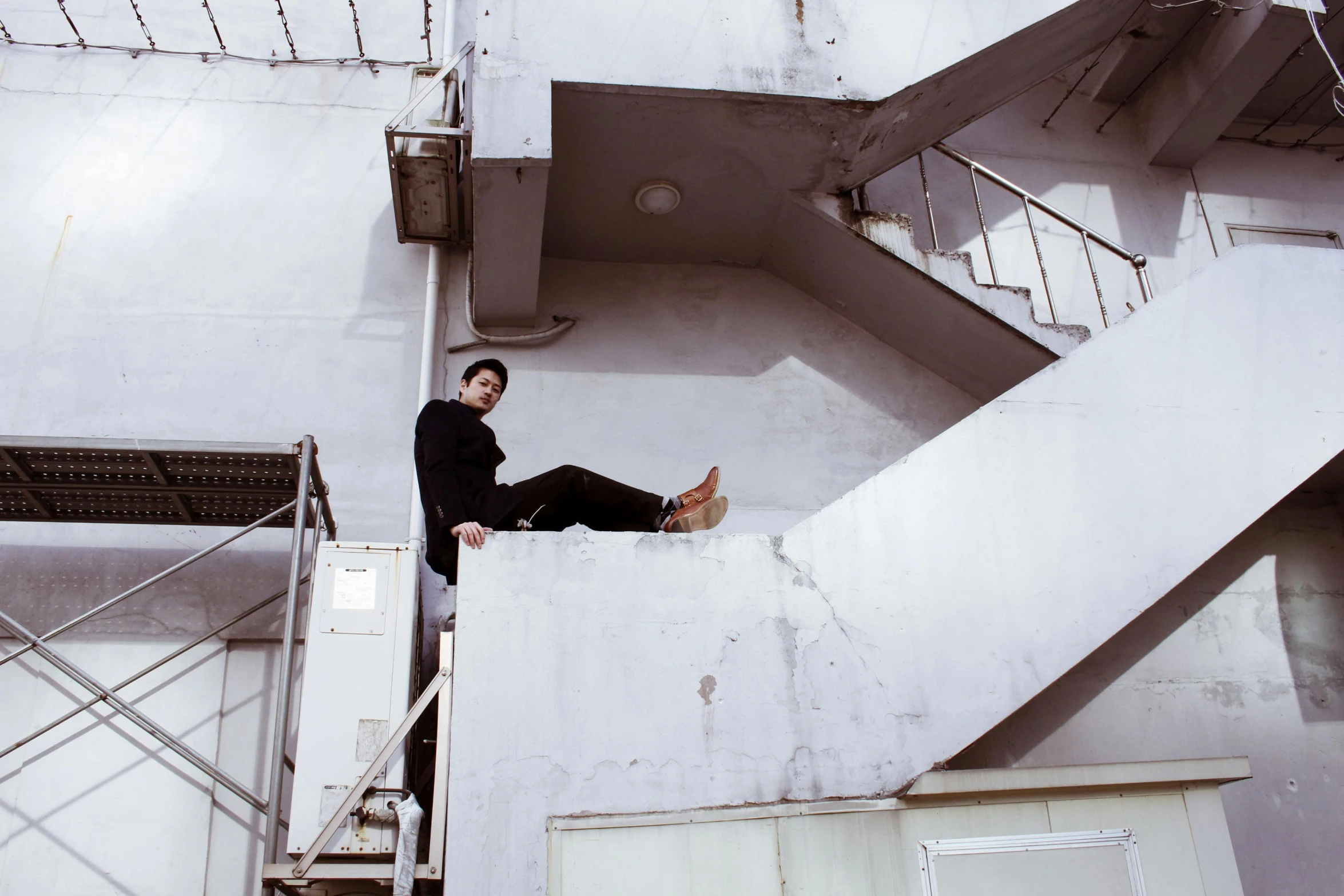 a man sitting on top of a set of stairs, inspired by Elsa Bleda, pexels contest winner, bauhaus, male ulzzang, orelsan, hozier, floating in mid - air