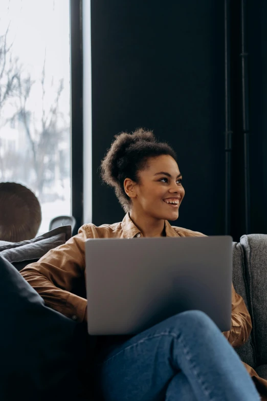 a woman sitting on a couch using a laptop, trending on pexels, renaissance, mixed-race woman, smiling slightly, avatar image, woman's profile