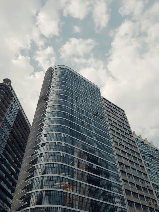a couple of tall buildings sitting next to each other, by Adam Rex, pexels contest winner, modernism, low quality footage, lots of glass details, curvy build, 4 k cinematic photo
