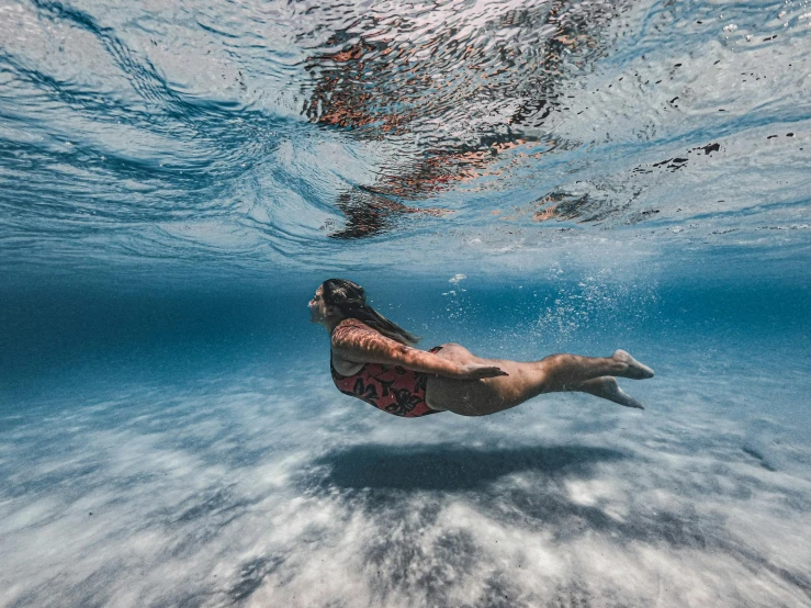 a man swimming in the ocean with a surfboard, an album cover, unsplash contest winner, portrait of a woman underwater, samoan features, 500px, upside - down