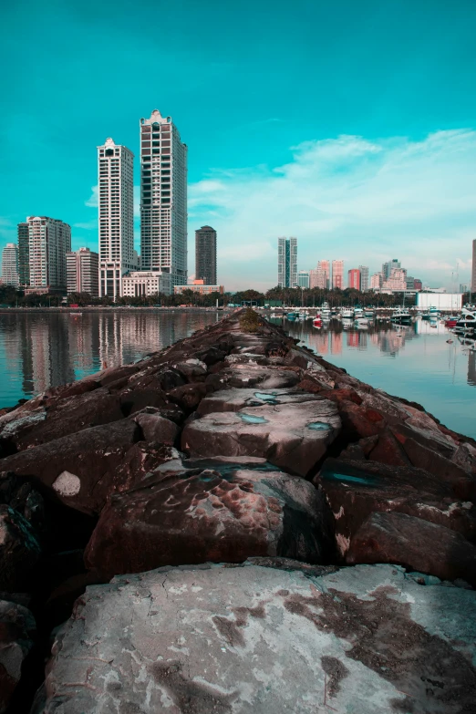 a large body of water with a city in the background, a colorized photo, by Basuki Abdullah, hyperrealism, near a jetty, high quality image, high rises, stepping stones