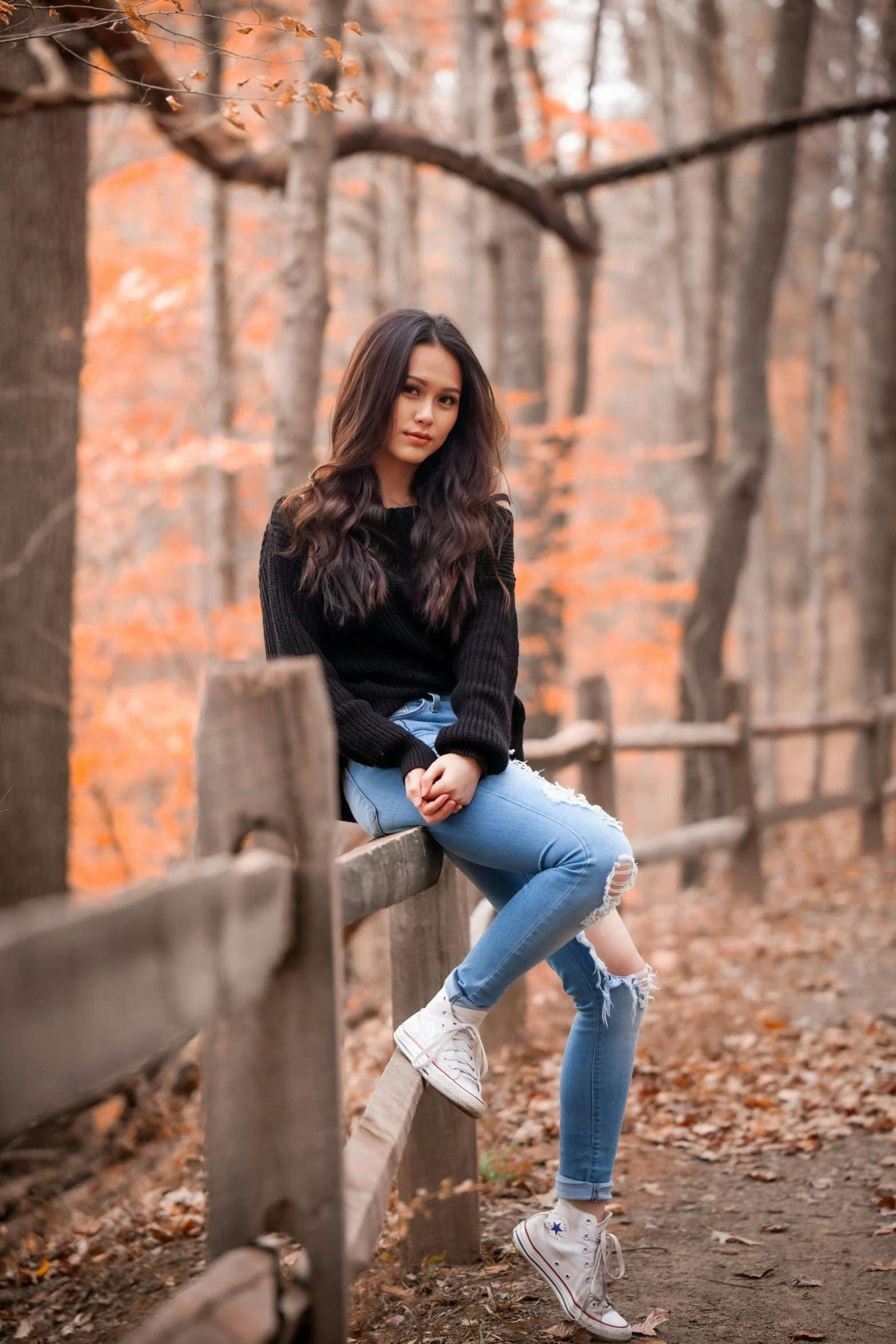 a woman sitting on a fence in the woods, by Robbie Trevino, black sweater, joanna gaines, casual streetwear, actress