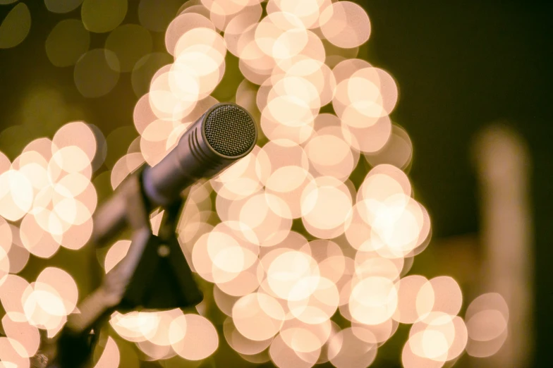 a microphone with lights in the background, an album cover, by Gavin Nolan, pexels, happening, christmas lights, bubbly, panels, 15081959 21121991 01012000 4k