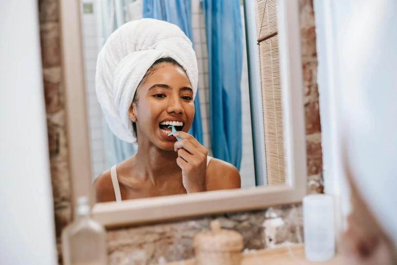 a woman brushing her teeth in front of a mirror, pexels contest winner, happening, manuka, candy treatments, mouth in mouth, beautiful morning