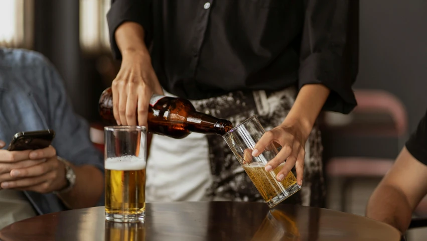 a woman pours a pint of beer into a glass, by Niko Henrichon, pexels, bottles of alcohol next to him, brown, caulfield, realistic depth