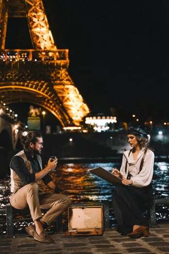 a man and a woman sitting in front of the eiffel tower, the river is full of lights, drinking, album, hey