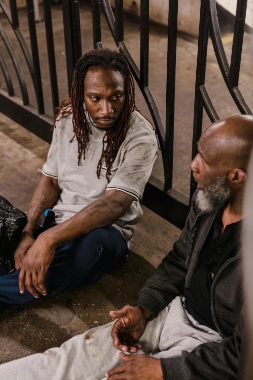 two men sitting next to each other on the ground, pexels contest winner, black arts movement, in jail, dreads, atiba jefferson, ( ( theatrical ) )