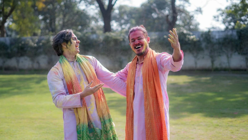 a couple of men standing on top of a lush green field, pexels, bengal school of art, wearing rainbow kimono, being delighted and cheerful, actors, wearing a kurta