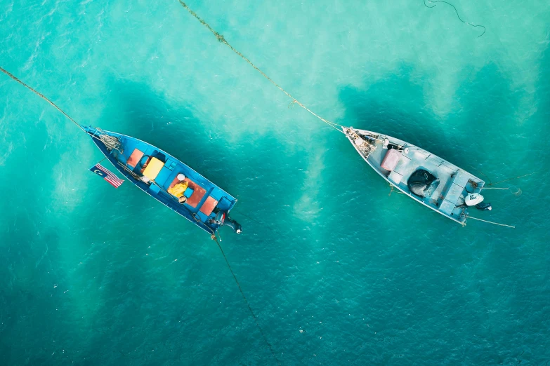 a couple of boats floating on top of a body of water, by Sebastian Spreng, pexels contest winner, hurufiyya, clear blue water, vivid colour, thumbnail, flatlay