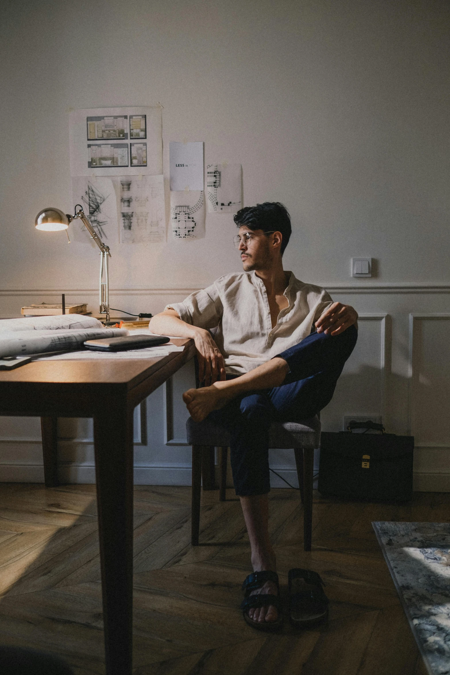 a man sitting at a desk in front of a laptop computer, by Tobias Stimmer, pexels contest winner, renaissance, non binary model, wearing a linen shirt, rick dai, sitting across the room