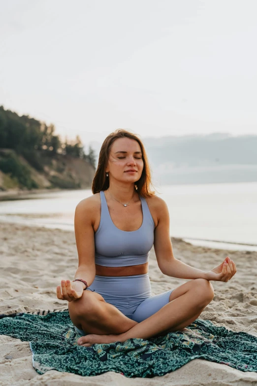 a woman is doing yoga on the beach, a portrait, unsplash, sitting down casually, portrait sophie mudd, center focused, uncropped