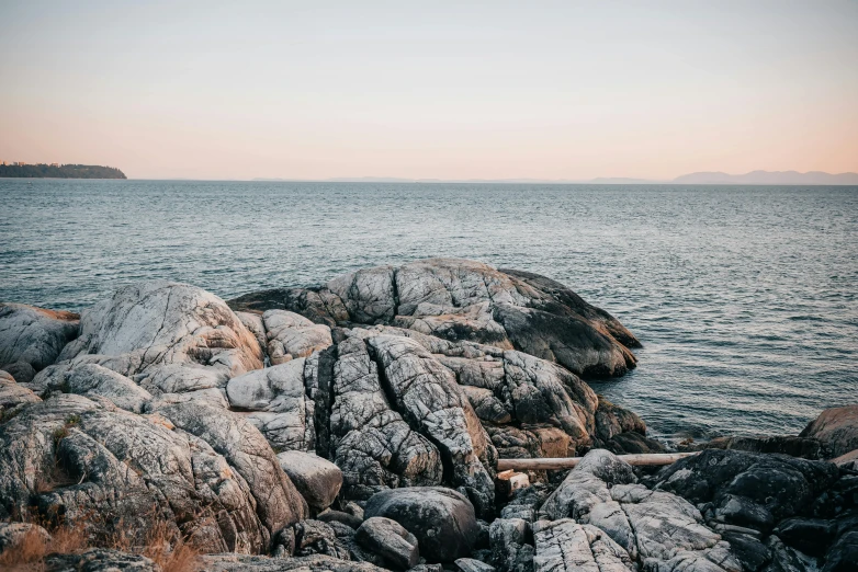 a large body of water next to a rocky shore, unsplash, minimalism, manly, summer evening, multiple stories, archipelago