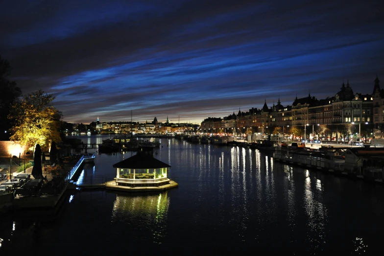 a boat that is sitting in the water, by Jesper Knudsen, pexels contest winner, hurufiyya, the river is full of lights, olafur eliasson, victorian harbour night, ikea