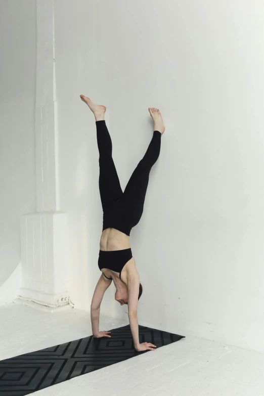 a person doing a handstand on a mat, by Carey Morris, arabesque, high quality image, sanja stikovic, vessels, wall