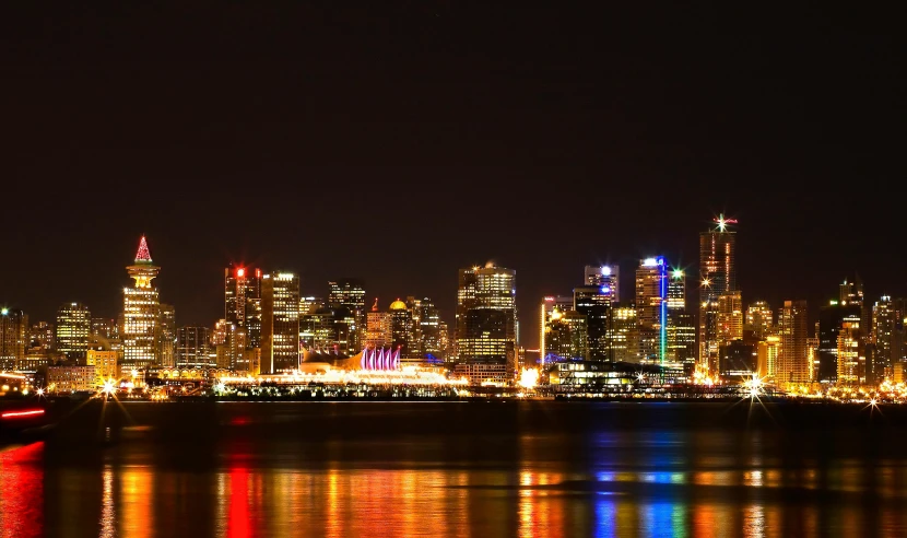 a view of a city at night from across the water, pexels contest winner, vancouver school, light show, plain background, multi colour, panoramic