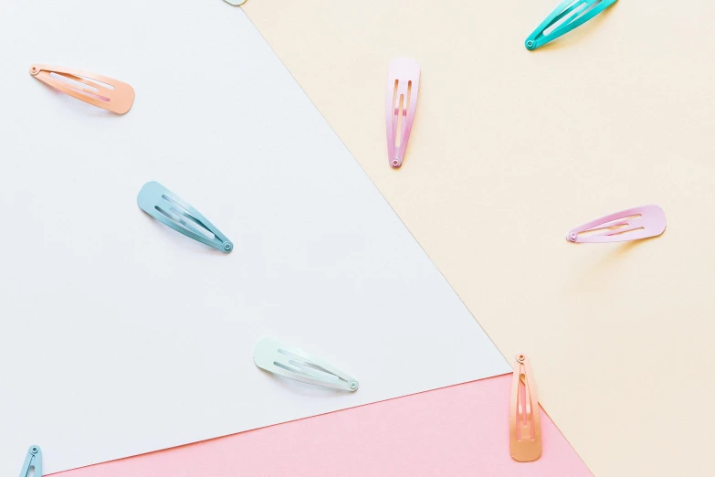 a bunch of paper clips sitting on top of a table, by Rachel Reckitt, trending on pexels, minimalism, long hair with pastel colors, gloss, pastel blue, clamp style