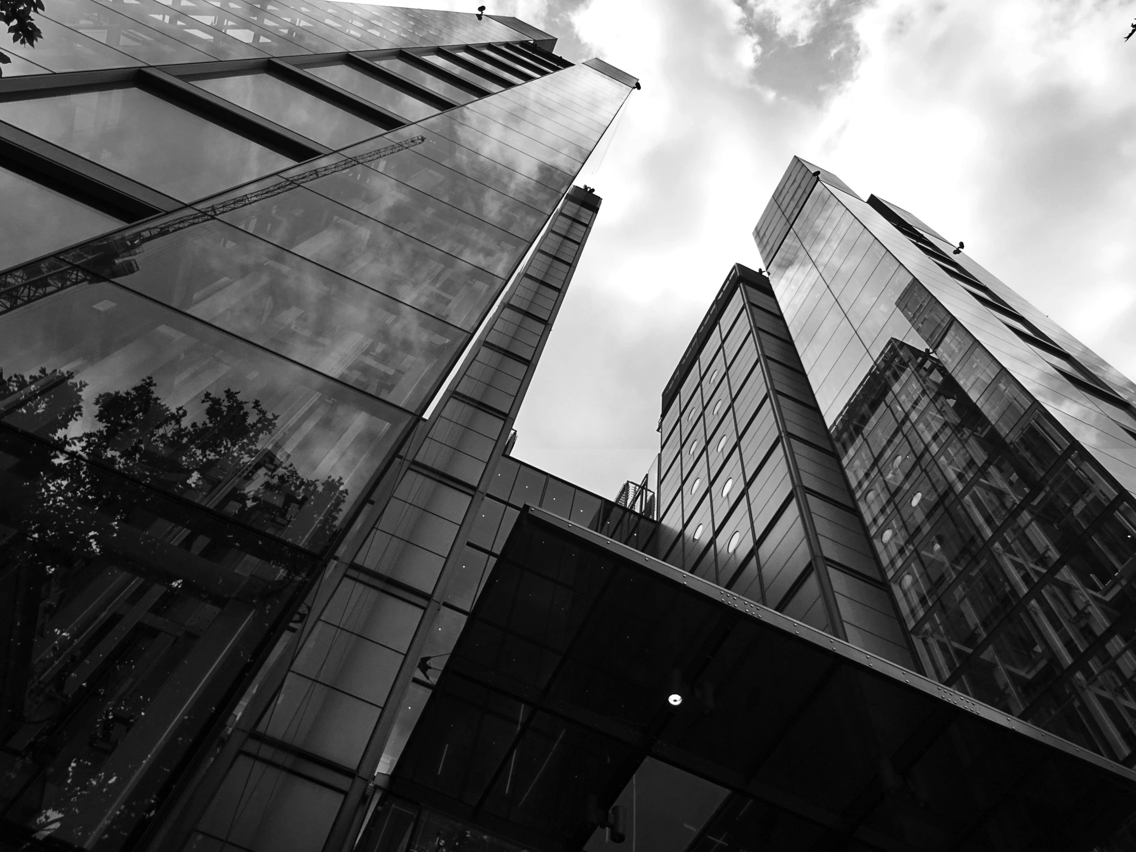 a black and white photo of some tall buildings, by Adam Rex, sleek glass buildings, square, high quality upload, trio