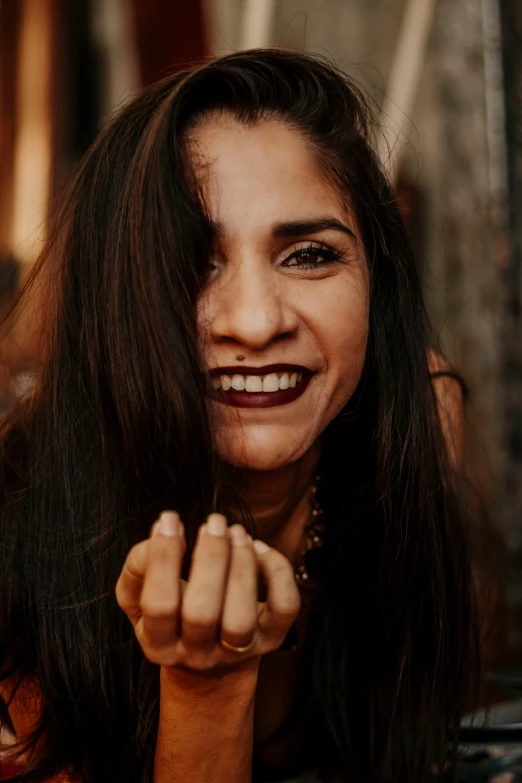 a close up of a person with long hair, pexels contest winner, dramatic smile pose, anjali mudra, grungy woman, with index finger