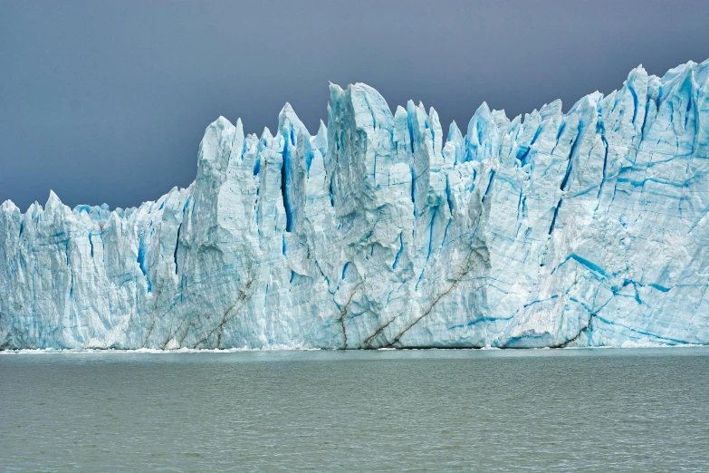 a large glacier in the middle of a body of water, by Alison Geissler, unsplash contest winner, hyperrealism, patagonian, armor made of ice, 2000s photo