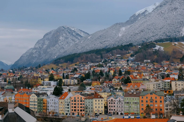 a view of a town with mountains in the background, by Johannes Voss, pexels contest winner, square, cold colors, wes anderson film, grey