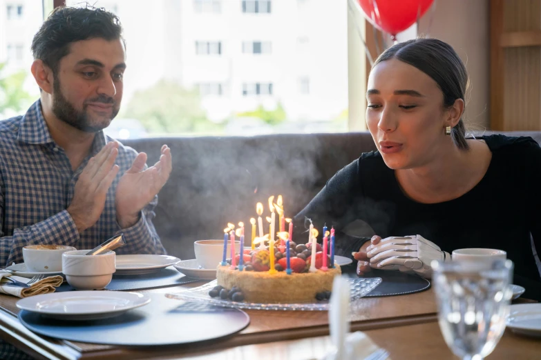 a woman blowing out candles on a birthday cake, pexels, hyperrealism, medium shot of two characters, people sitting at tables, background image, smoke behind