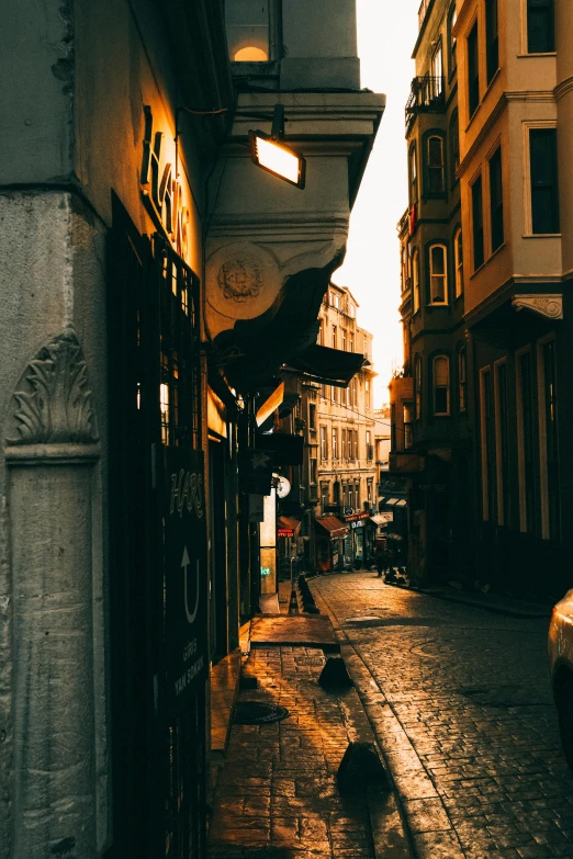 a car parked on the side of a street next to tall buildings, a picture, pexels contest winner, renaissance, istanbul, doorways, late afternoon lighting, baroque winding cobbled streets