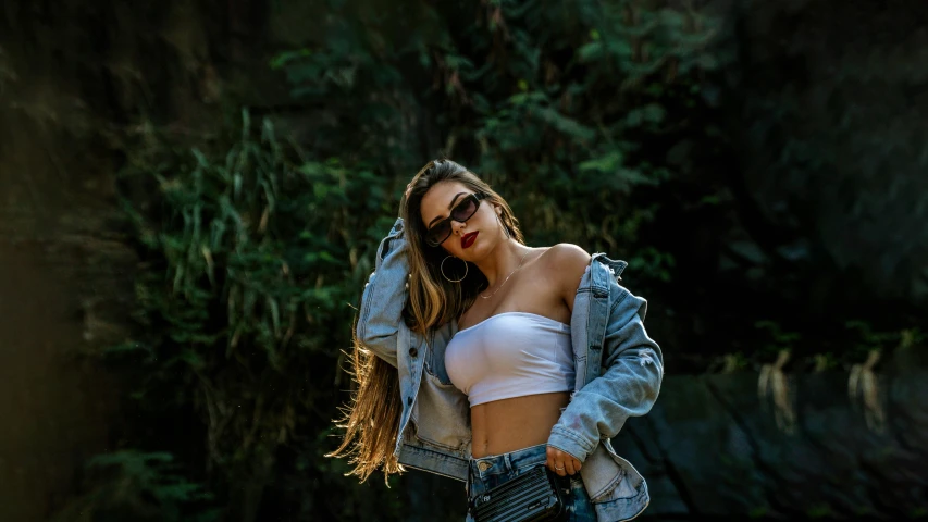 a beautiful young woman standing in front of a waterfall, inspired by Elsa Bleda, trending on pexels, graffiti, bra and shorts streetwear, jean jacket, with sunglass, white bra