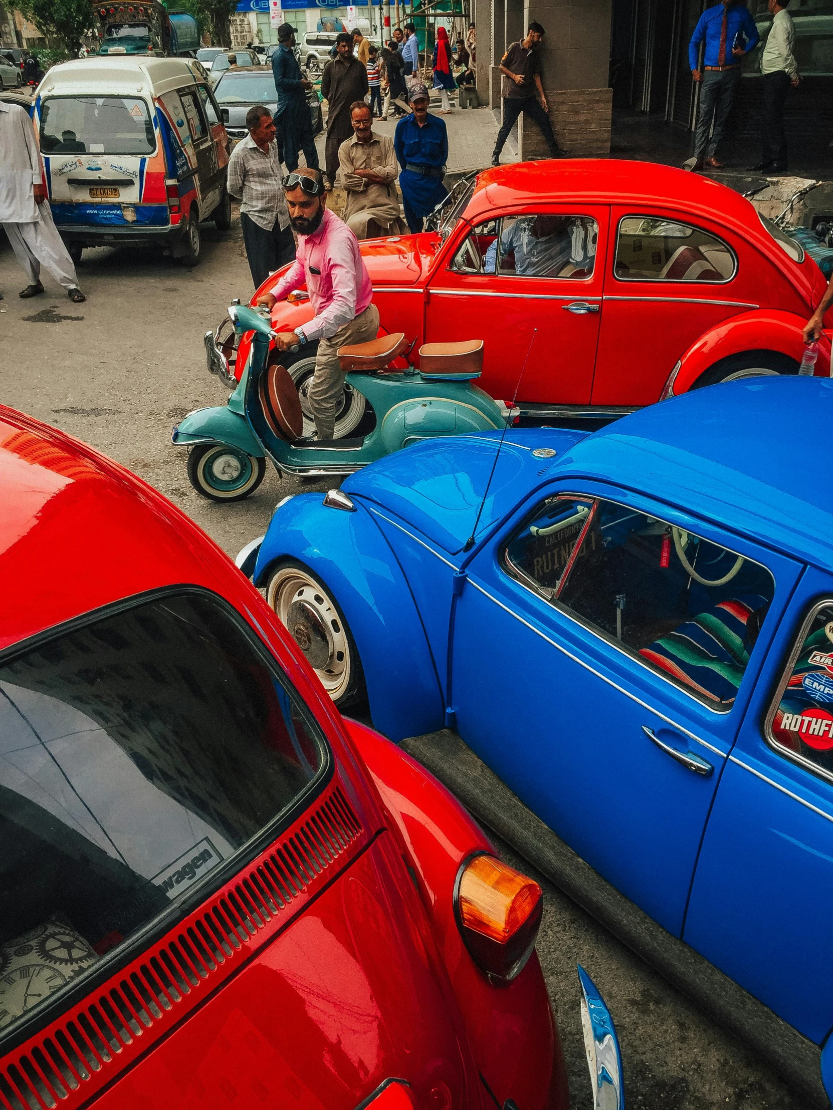 a group of cars parked next to each other on a street, a colorized photo, inspired by Steve McCurry, pexels contest winner, hyperrealism, dhaka traffic, beetle, blue and red, with an intricate