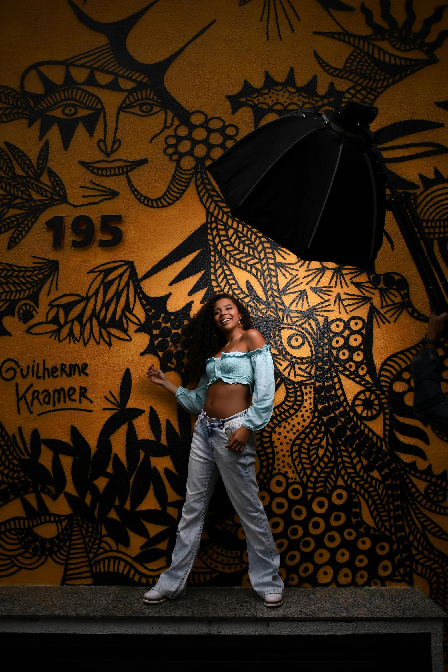 a woman standing in front of a wall with a black umbrella, an album cover, inspired by Fritz Glarner, shutterstock contest winner, graffiti, 2 5 6 x 2 5 6, madison beer girl portrait, keith harring, photographed for reuters