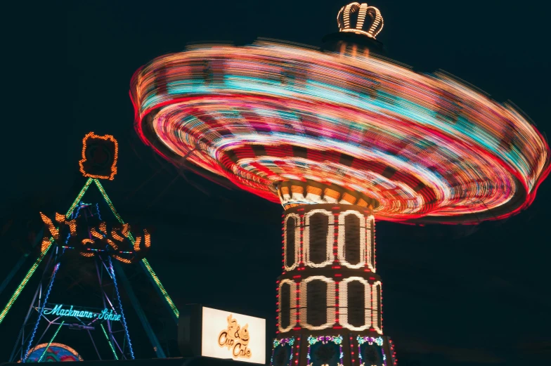 a blurry photo of a carnival ride at night, a digital rendering, by Adam Marczyński, pexels contest winner, unsplash 4k, flying saucers, ilustration, high - contrast