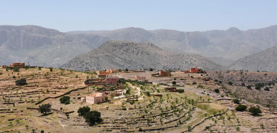 a village in the middle of a valley with mountains in the background, trending on unsplash, les nabis, moroccan, john pawson, 2 0 0 0's photo, multiple stories