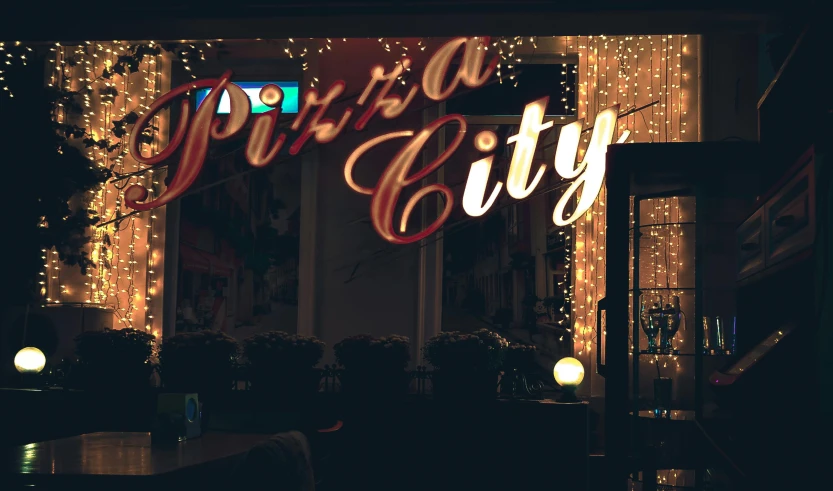 a couple of people sitting at a table in front of a window, by Julia Pishtar, pexels contest winner, graffiti, futuristic pizza hut at night, typography, paradise city, 💋 💄 👠 👗