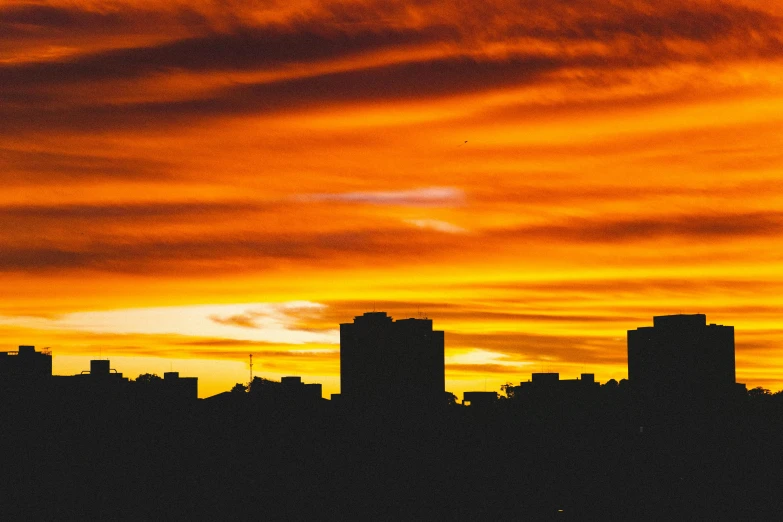 a plane flying over a city at sunset, an album cover, pexels contest winner, brutalism, buenos aires, silhouette :7, sunset panorama, red+yellow colours