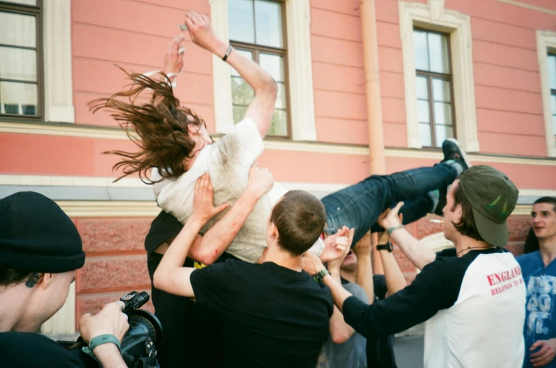 a group of people standing around a man on a skateboard, pexels contest winner, sots art, headbanging, in russia, ryan mcginley, extremely long hair