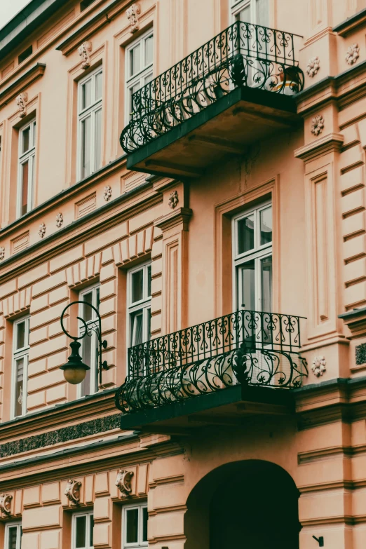 a building with a motorcycle parked in front of it, pexels contest winner, art nouveau, balconies, rococo details, warsaw, black and terracotta