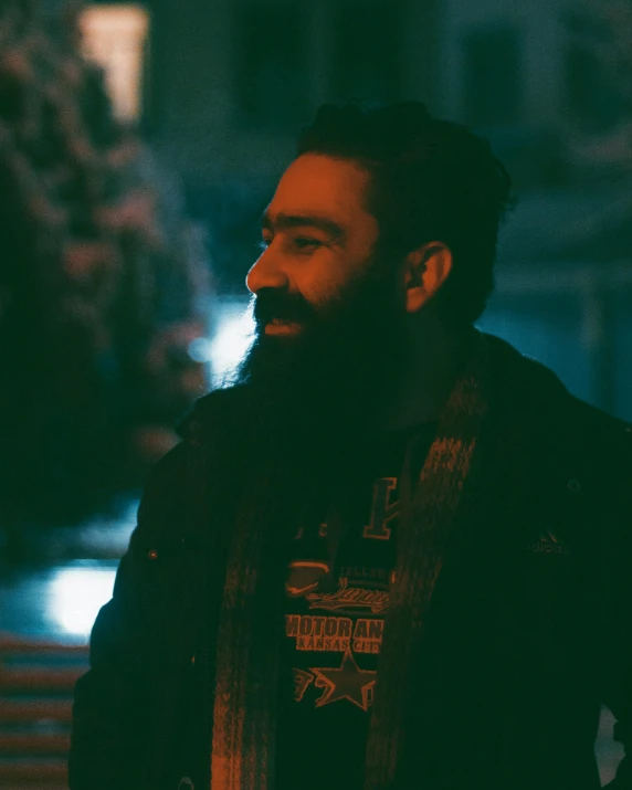 a man with a beard standing in front of a building, inspired by Liam Wong, pexels contest winner, hurufiyya, bisexual lighting, profile image, looking happy, dark red beard