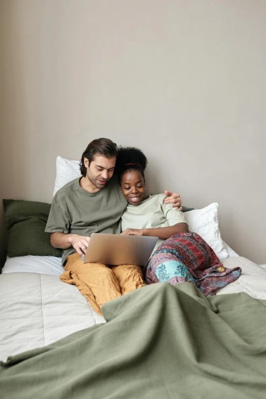 a man and woman sitting on a bed with a laptop, lgbtq, instagram picture, diverse, cuddling