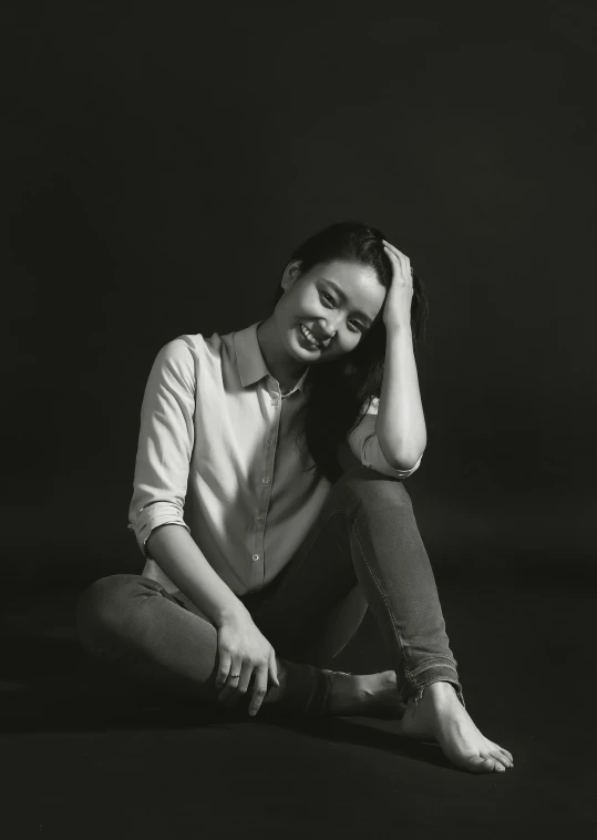 a black and white photo of a woman sitting on the ground, inspired by Fei Danxu, pexels contest winner, photorealism, studio!! portrait lighting, satisfied pose, casual pose, pastel'