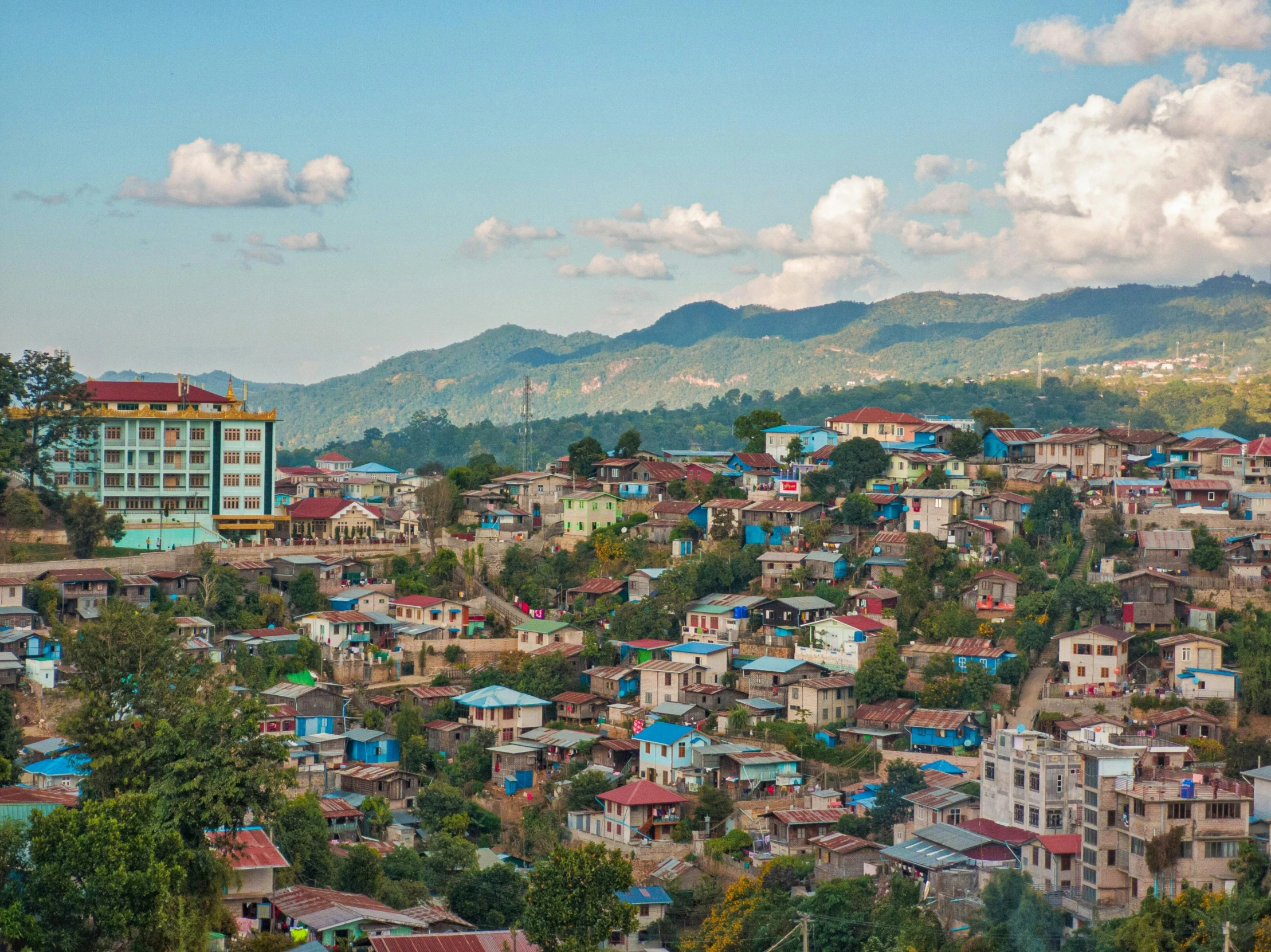 a view of a town from the top of a hill, myanmar, multicoloured, slide show, cyan