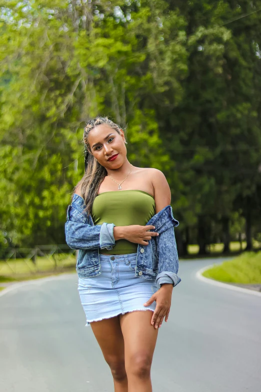 a woman riding a skateboard down a road, by reyna rochin, instagram, happening, in front of a forest background, wearing yellow croptop, portrait mode photo, wearing a jeans jackets