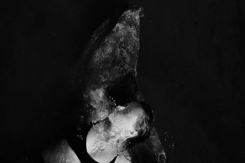 a black and white photo of a person in the water, an album cover, by Caro Niederer, unsplash, conceptual art, devouring, dolphin swimming, ffffound, liquid light