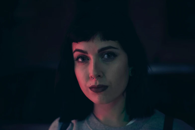 a woman with dark hair and piercings in a dark room, inspired by Elsa Bleda, pexels contest winner, serial art, cinematic pastel lighting, portrait of max caulfield, cinestill 800t film photo, charli xcx