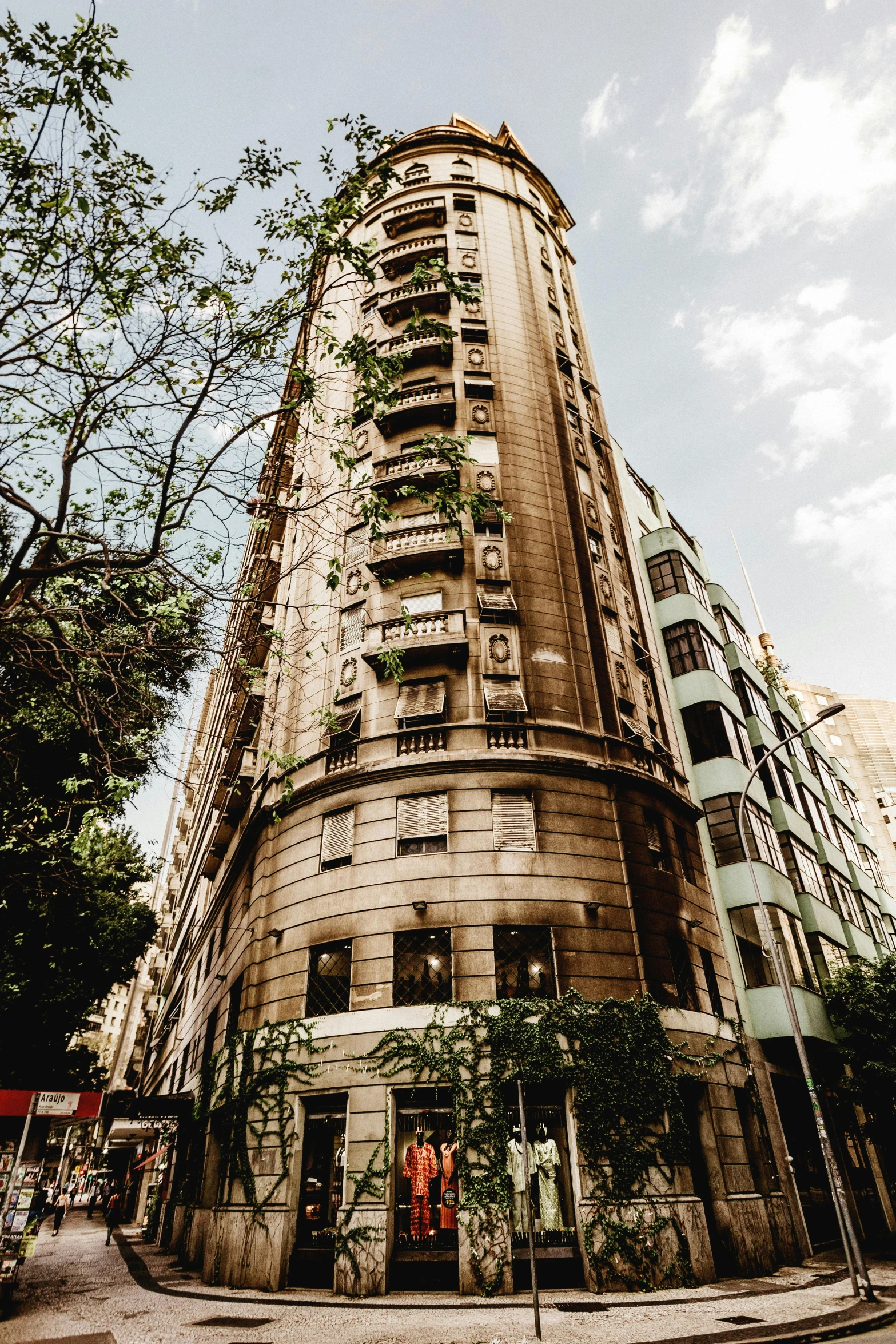 a tall building sitting on the side of a street, inspired by Ricardo Bofill, pexels contest winner, art nouveau, buenos aires, lush surroundings, high resolution photograph, cairo