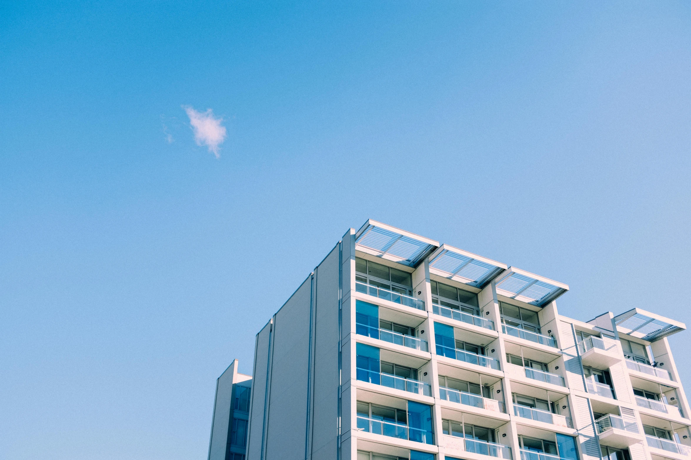 a tall building with balconies on top of it, by Lee Loughridge, unsplash, modernism, caulfield, cloudless sky, ignant, photo of breeze kaze